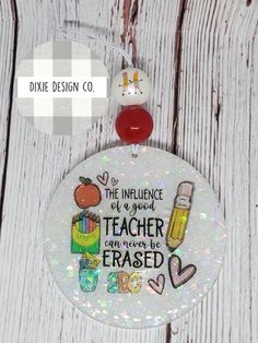 a white ornament with an image of teacher on it and the words dixie design co