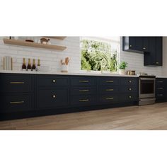 a kitchen with black cabinets and gold handles