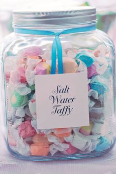 a jar filled with lots of colorful candies and a tag that says salt water taffy