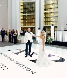 a bride and groom dancing on the dance floor at their wedding reception in front of an audience