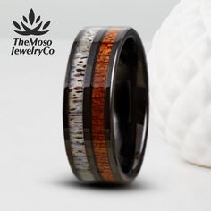 a ring with wood and antler inlays is shown next to a white ball