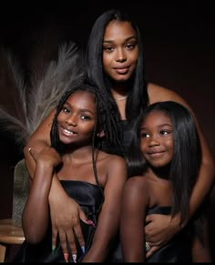 two women and one girl are posing for the camera