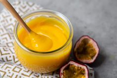 a glass jar filled with orange juice next to some cut up fruit on a napkin