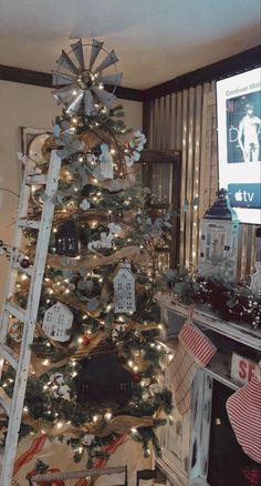 a decorated christmas tree in the corner of a living room with an old ladder leaning against it