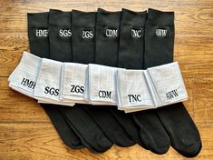 five pairs of socks with names on them sitting on a wooden floor next to each other