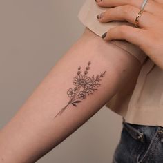 a woman's arm with a flower tattoo on the left side of her arm