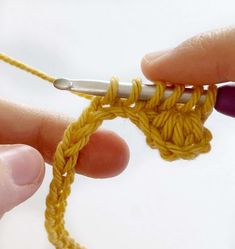 someone crocheting the end of a piece of yellow yarn