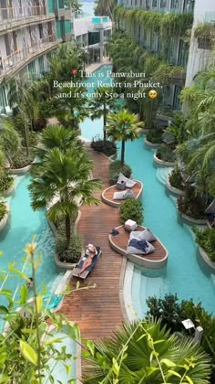 two people are sitting on benches in the middle of an outdoor swimming pool that is surrounded by palm trees