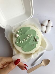 a woman's hand next to a cake with the word mom written on it