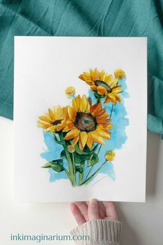 a person holding up a card with sunflowers on it