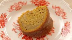 a piece of cake sitting on top of a white and red flowered saucer