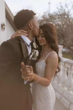 a bride and groom kissing on the balcony