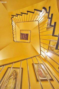 a spiral staircase with pictures on the wall