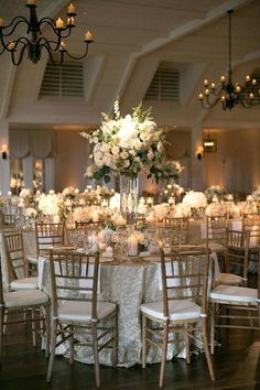 the tables are set with white flowers and candles