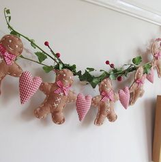 christmas decorations with teddy bears and holly on a wall hanging from a line in front of a door