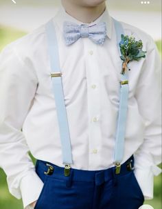 a young boy in a white shirt and blue suspenders is wearing a bow tie