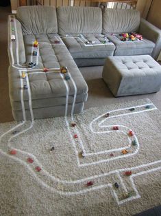 a couch with legos on the floor next to a footstool and ottoman