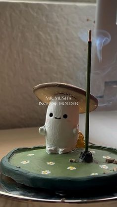 a small toy with a straw hat on top of it sitting on a saucer