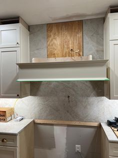 an unfinished kitchen with white cabinets and counter tops is being built into the wall above the stove