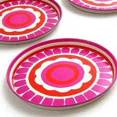 three pink and red plates sitting next to each other