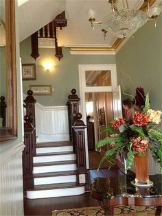 a vase filled with flowers sitting on top of a table next to a stair case