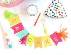 a birthday party with cake and decorations on the table, including a cupcake topper