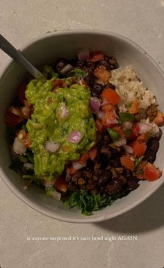 a white bowl filled with rice, beans and guacamole