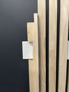 an electrical outlet is attached to the side of a wooden wall with black and white trim