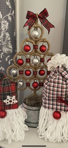 a small christmas tree with ornaments around it and other decorations on top of the table