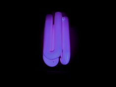 two neon purple toothbrushes in the dark