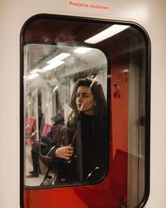 a woman looking out the window of a train