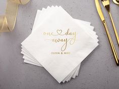 white napkins with gold foil lettering on them next to forks, knife and fork