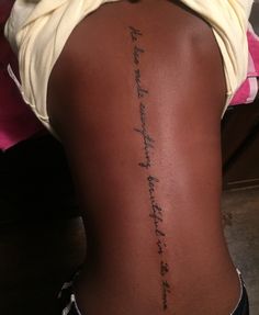 the back of a woman's lower body with writing on her left side ribcage