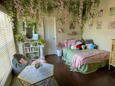 a bedroom decorated in pastel colors with pink and green flowers hanging from the ceiling