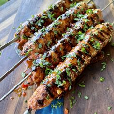 several skewers of chicken on a wooden table