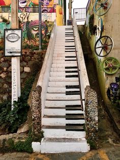 an old set of stairs with graffiti painted on the walls behind it and below them