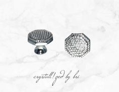 two silver knobs sitting on top of a white marble surface with the words crystaled by