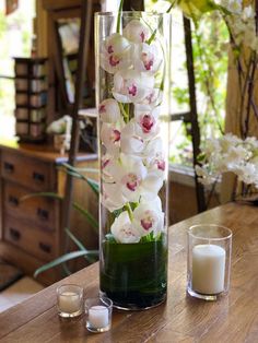 a vase with flowers and candles on a table