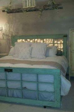 the bed frame is made from doors and has been painted green with white trims