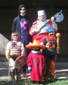 some people are dressed up in costumes and posing for a photo with two children on the grass