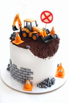 there is a cake that has construction equipment on the top and dirt in the middle