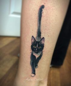 a black and white cat tattoo on the right leg, it appears to be an ink painting