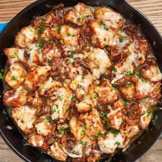 a skillet filled with food on top of a wooden table