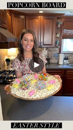 a woman holding a platter full of candy and candies with the words popcorn board on it