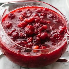 a glass bowl filled with cranberry sauce on top of a table