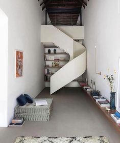 a living room with a spiral stair case in the center and an area rug on the floor