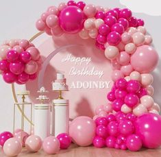 a pink and white birthday party with balloons