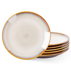 four plates stacked on top of each other in different colors and sizes, with gold rims