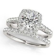 a white gold ring set with an oval cut diamond surrounded by round brilliant pave diamonds