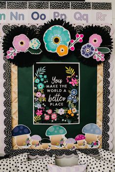 an art piece with flowers and words on it in the shape of a frame that says you are the world a better place